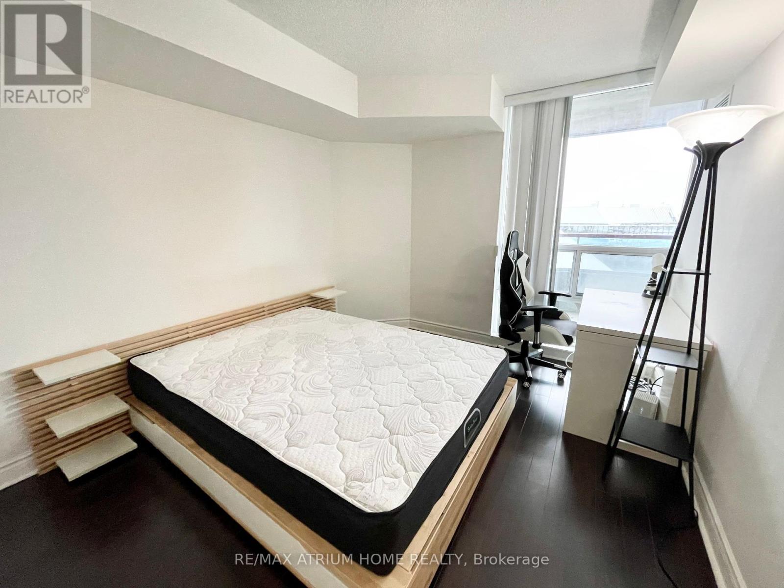 A bedroom with a large bed and a window.
