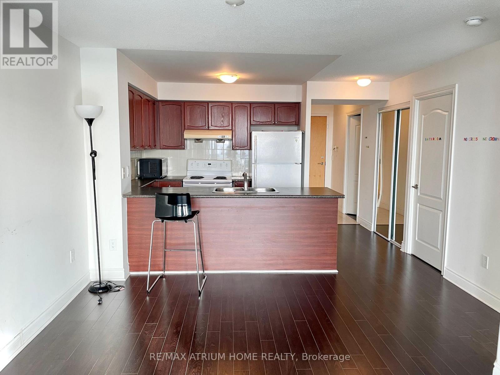 A kitchen with brown cabinets and a white fridge.