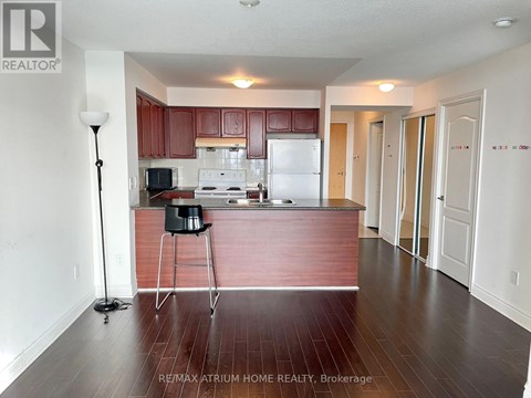 A kitchen with brown cabinets and a white fridge.