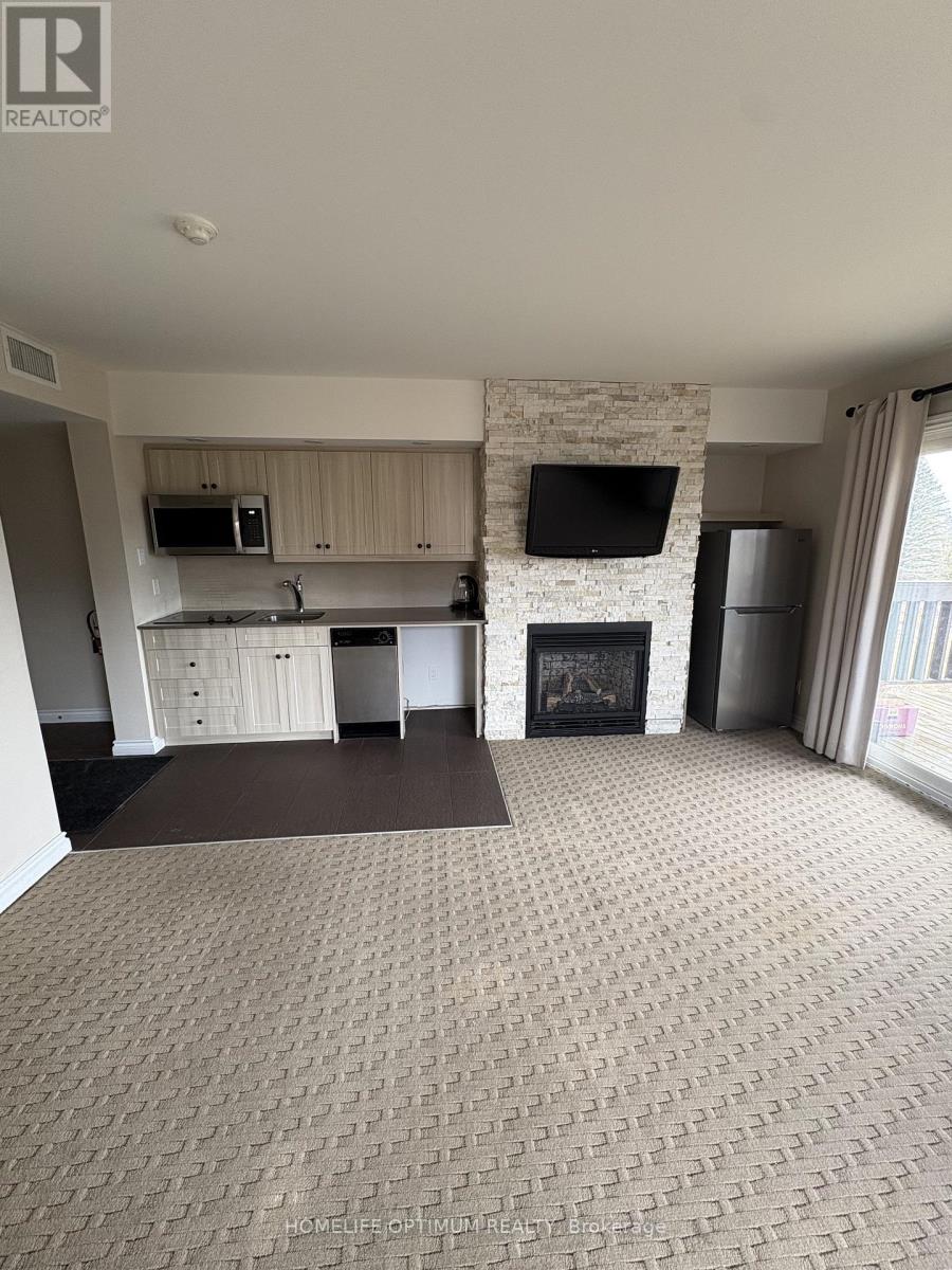 A living room with a fireplace and a tv on the wall.
