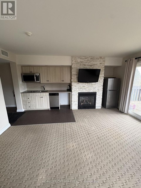 A living room with a fireplace and a tv on the wall.