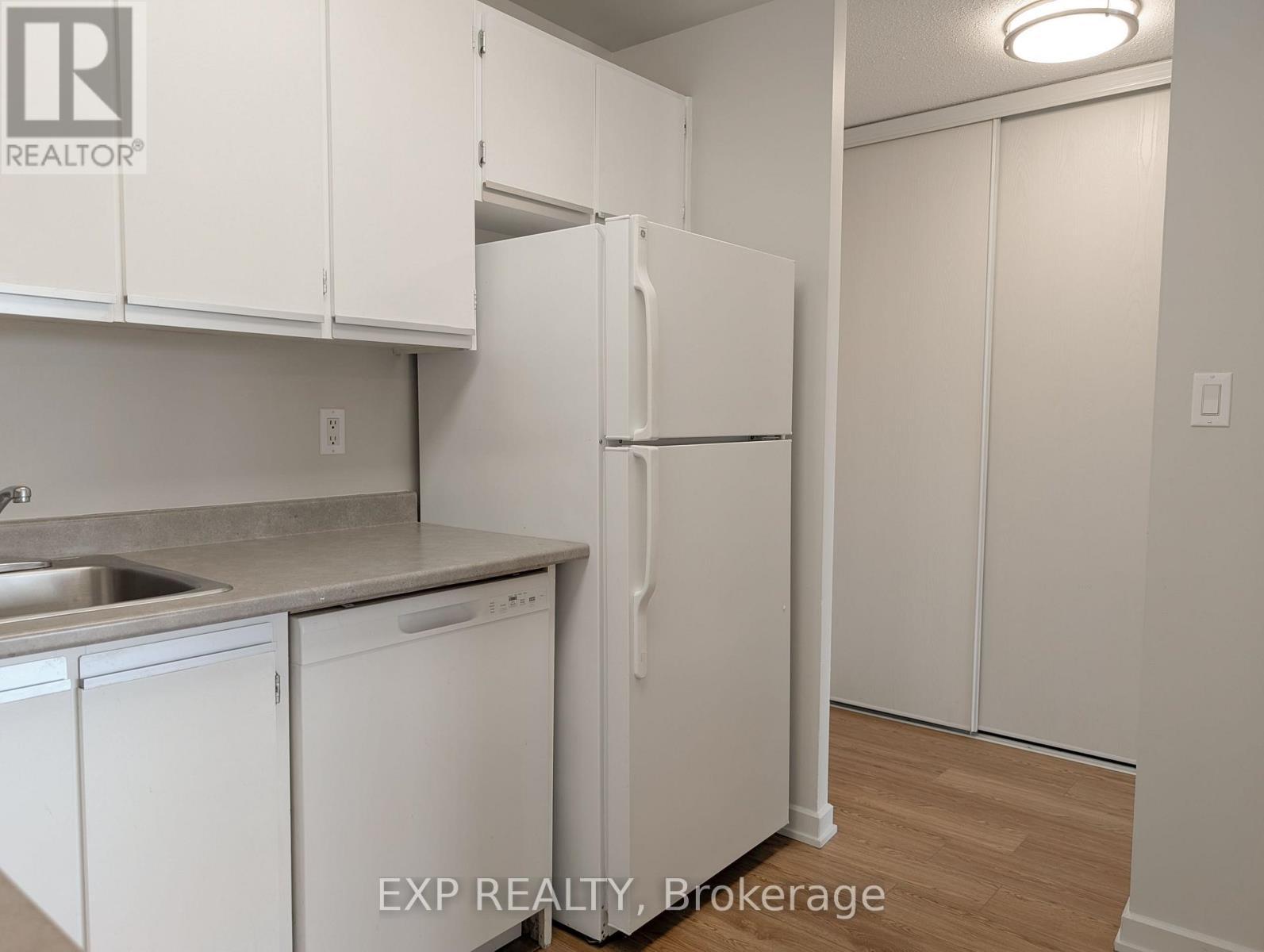 A kitchen with white cabinets and a white refrigerator.