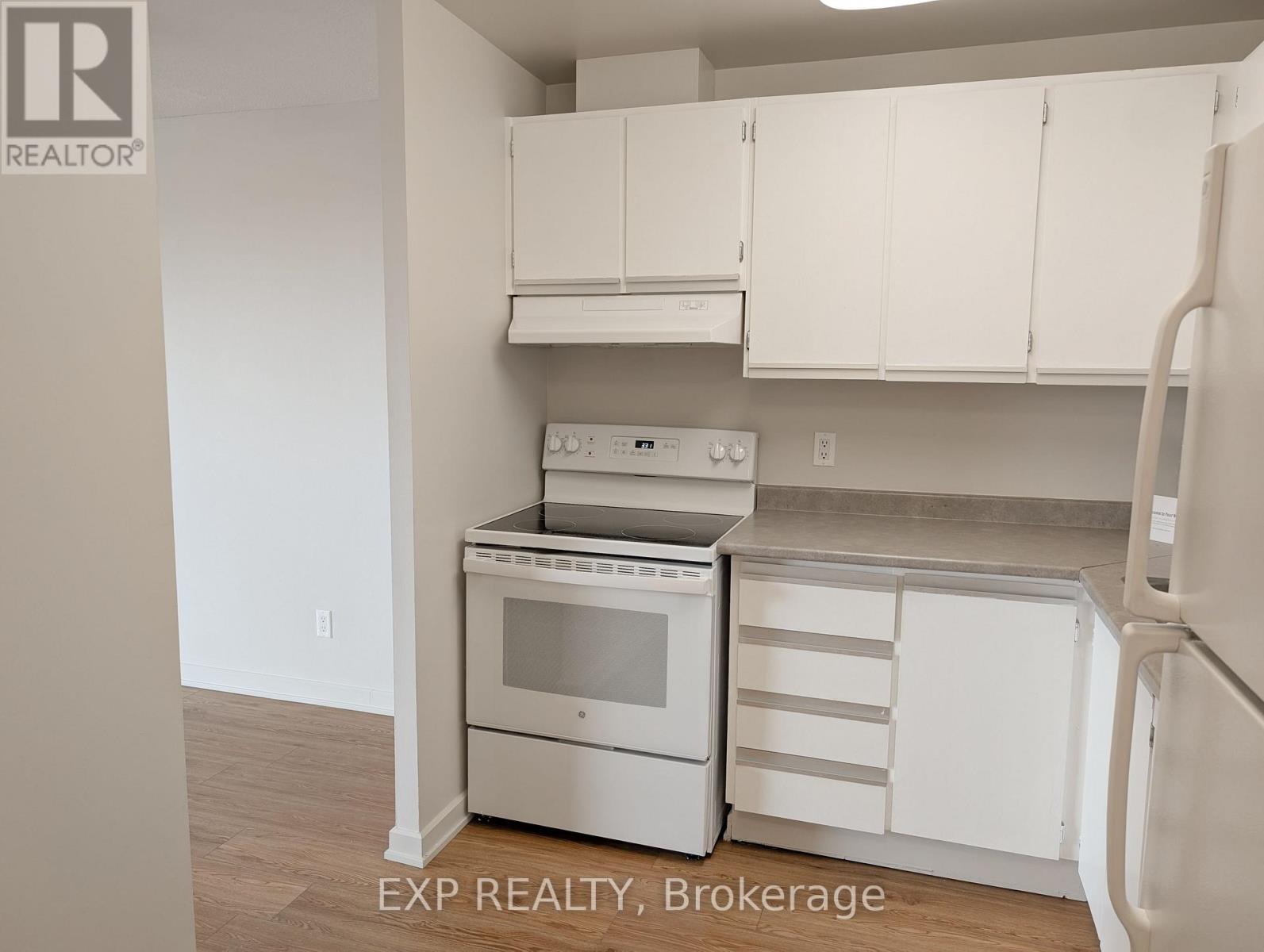 A kitchen with white cabinets and appliances.
