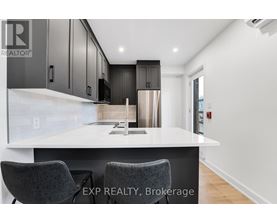 A modern kitchen with a white countertop and dark cabinets.