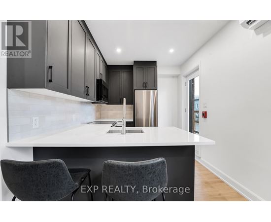 A modern kitchen with a white countertop and dark cabinets.