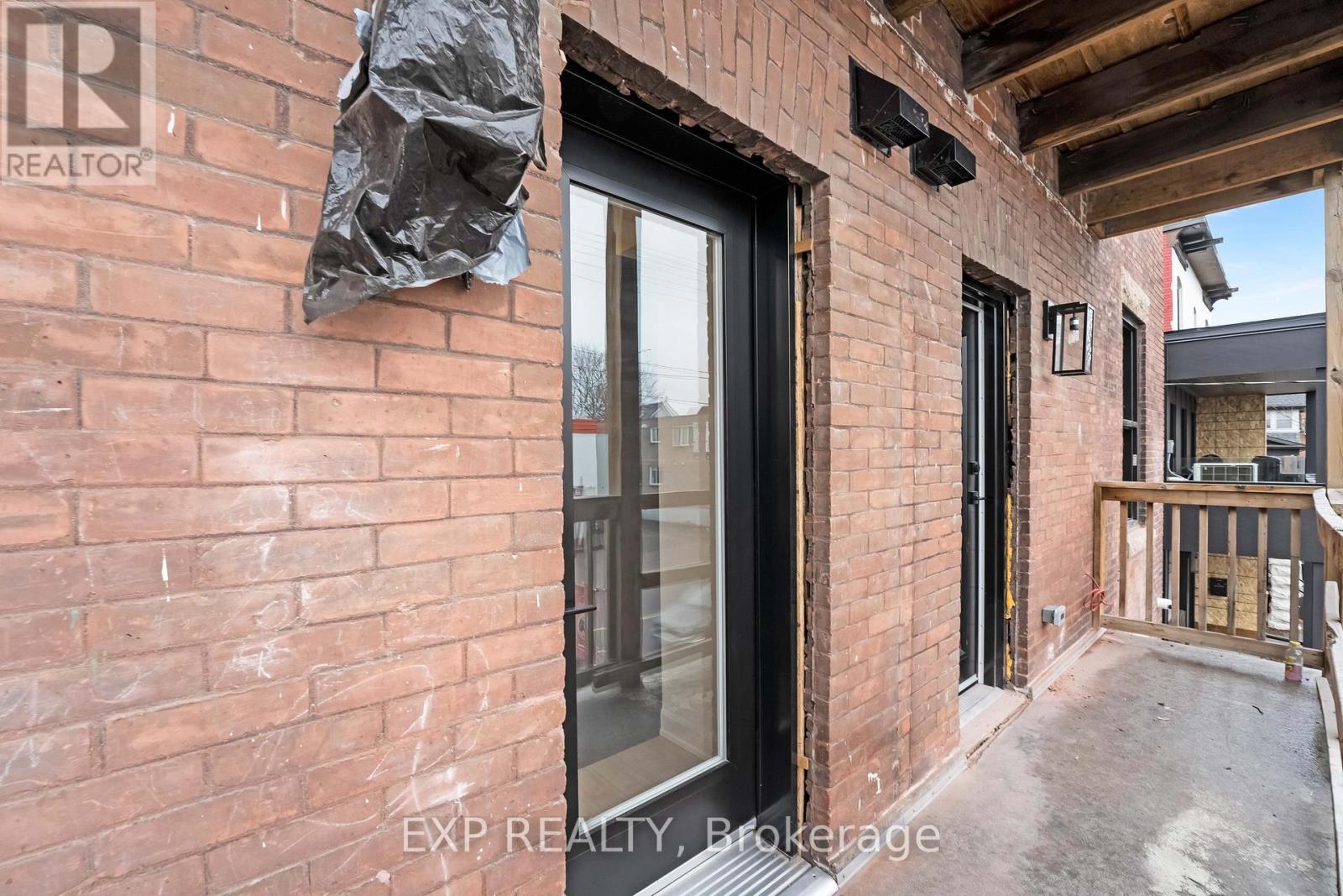 A brick building with a black door and windows.