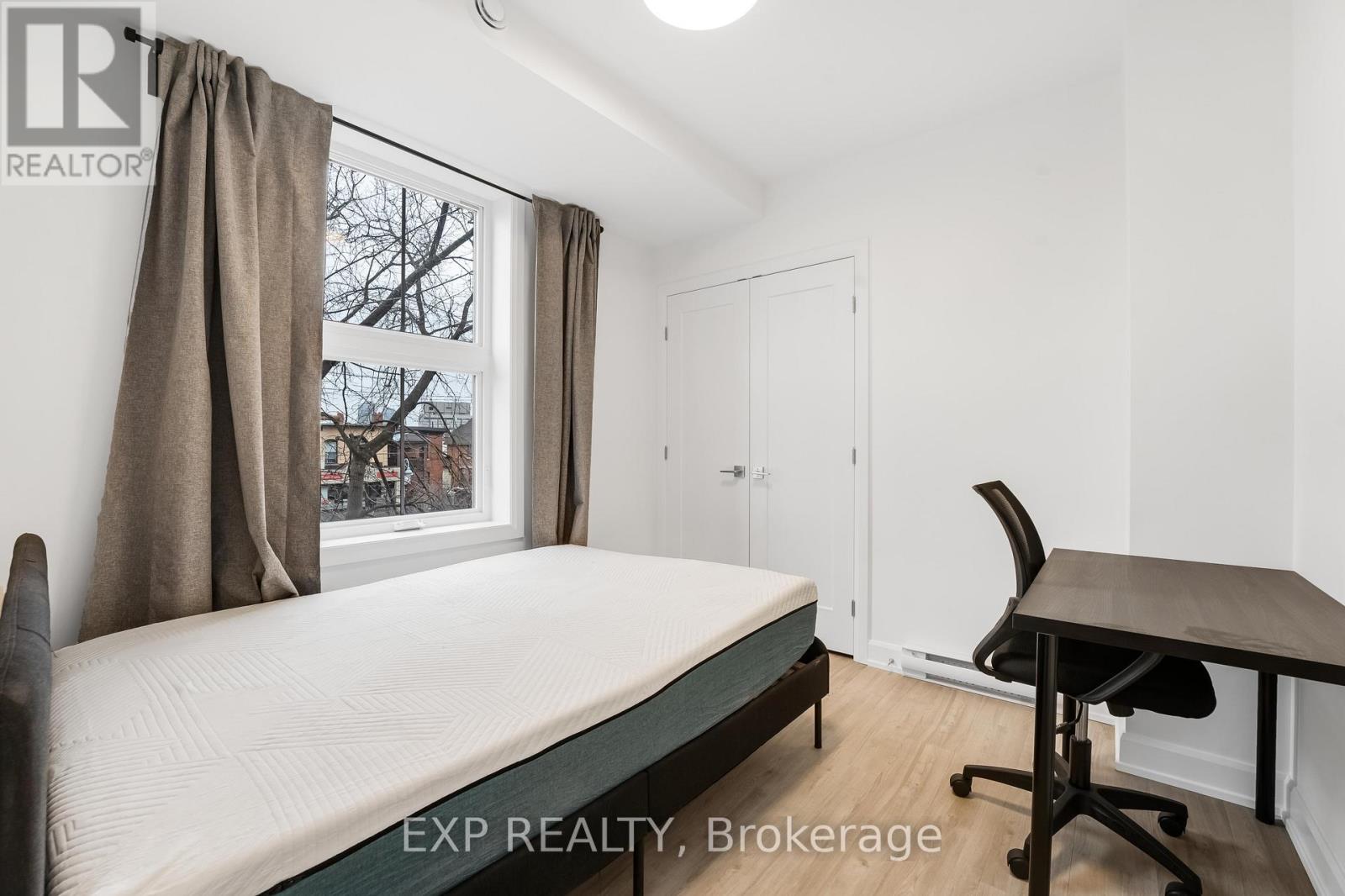 A bedroom with a bed, desk, and chair.