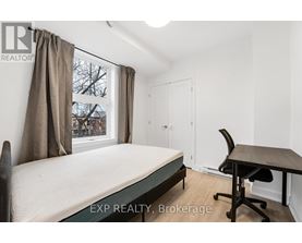 A bedroom with a bed, desk, and chair.