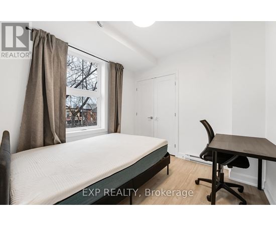 A bedroom with a bed, desk, and chair.