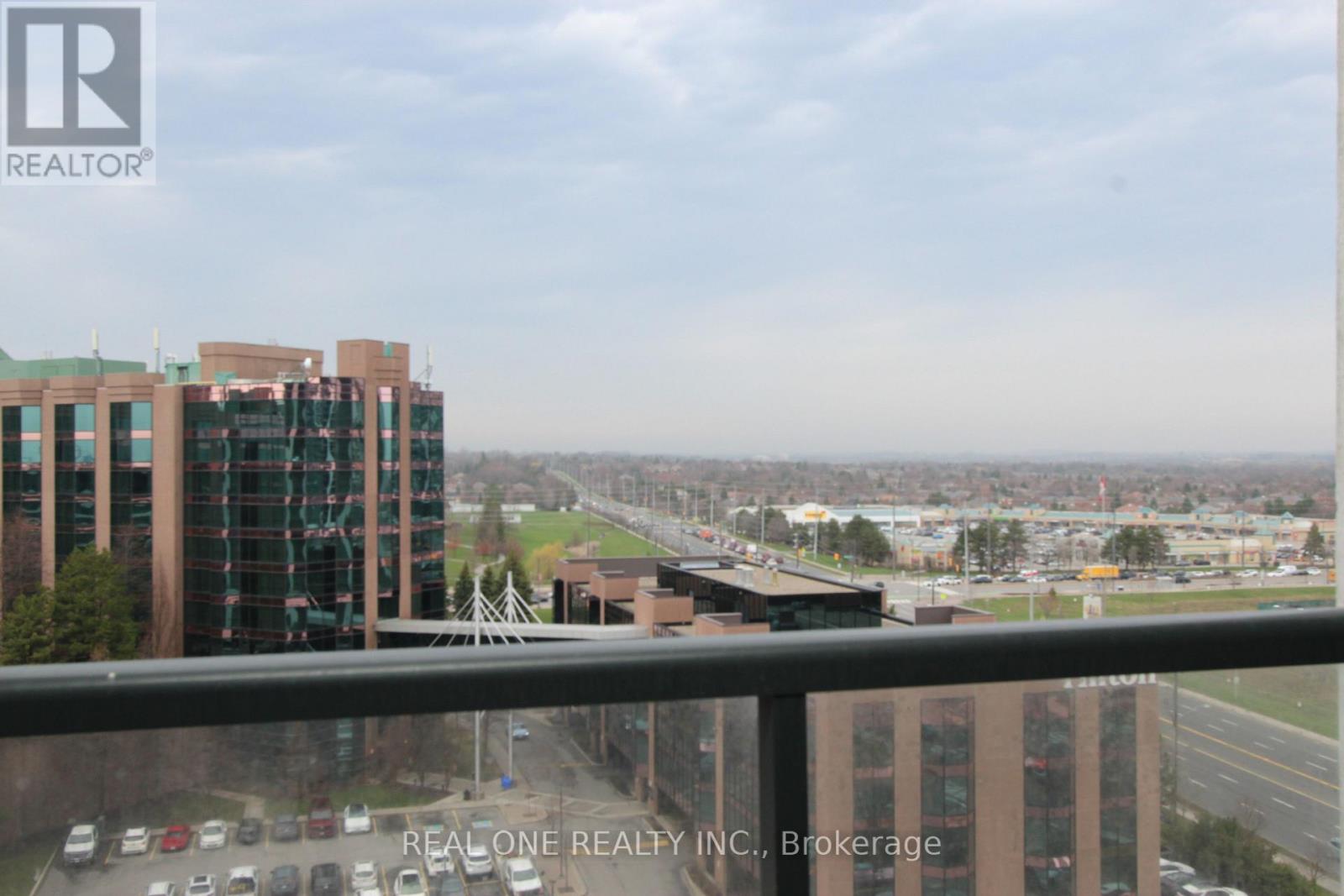 A view from a high-rise building showing a parking lot and other buildings.