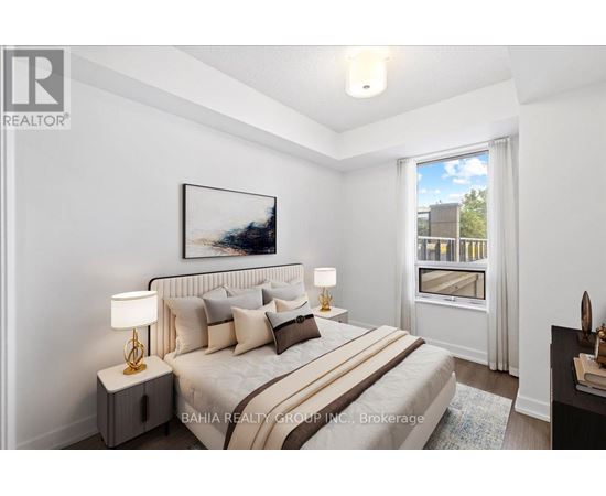 A well-lit bedroom with a large bed and a painting on the wall.