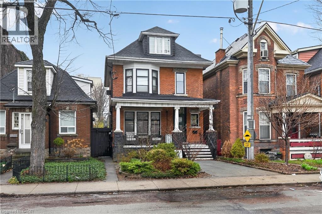 A large red brick house with a black door and a small porch.