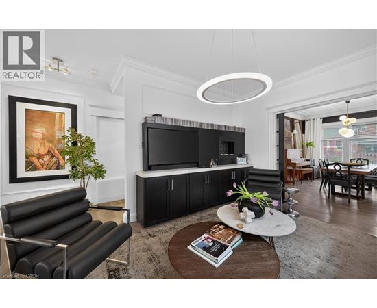 A living room with a black leather sofa and a television.