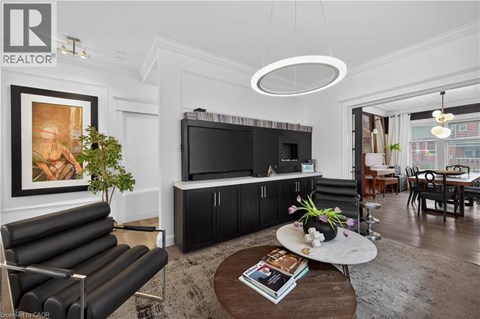 A living room with a black leather sofa and a television.