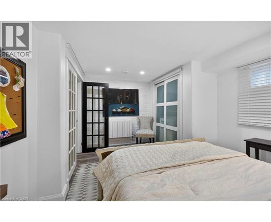 A bedroom with a large bed and a chair in the corner.