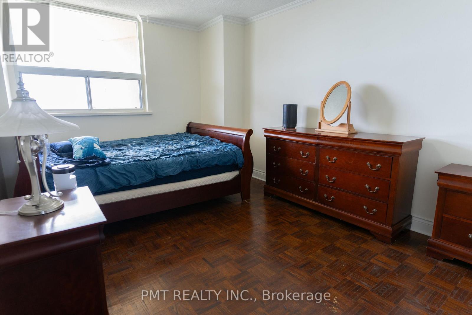 A bedroom with a bed, dresser, and nightstand.