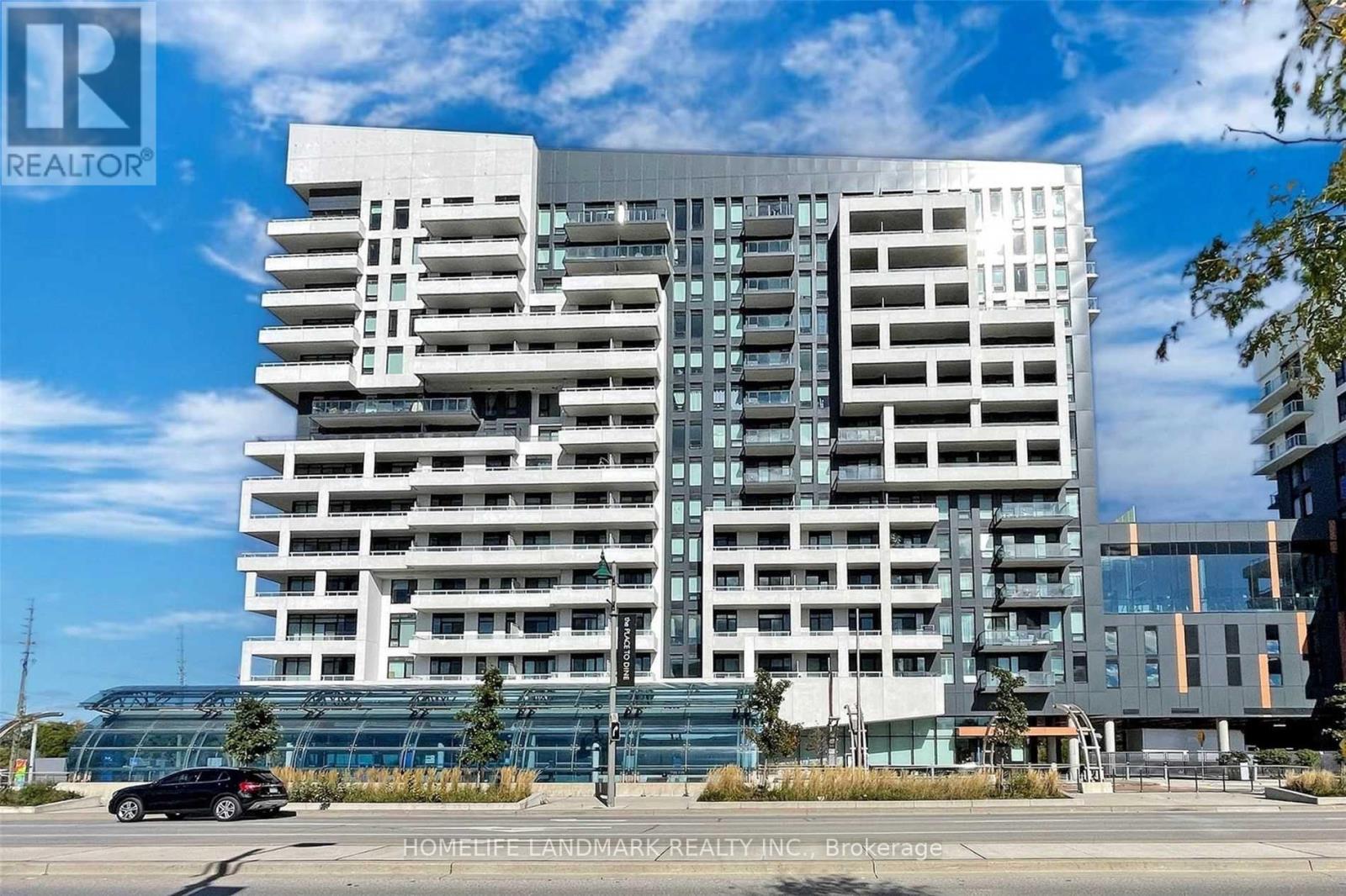 A large white building with a black car in front of it.