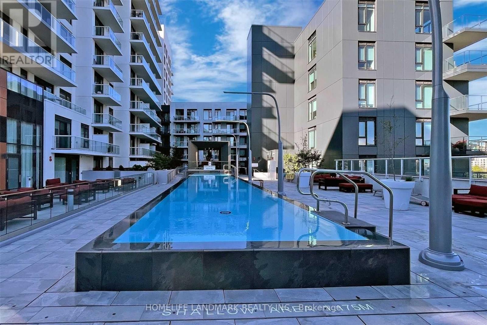 A swimming pool in the middle of a courtyard surrounded by buildings.