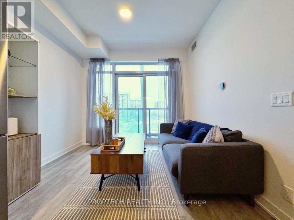 A living room with a grey couch and a wooden coffee table.