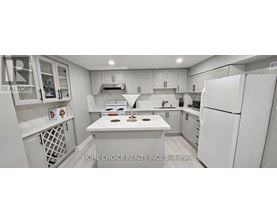 A white kitchen with a refrigerator, sink, and stove.
