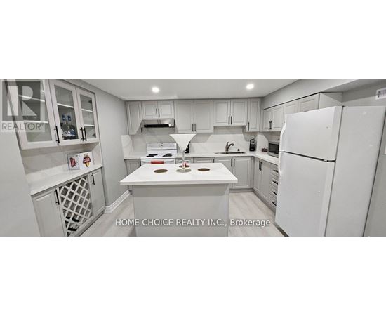 A white kitchen with a refrigerator, sink, and stove.