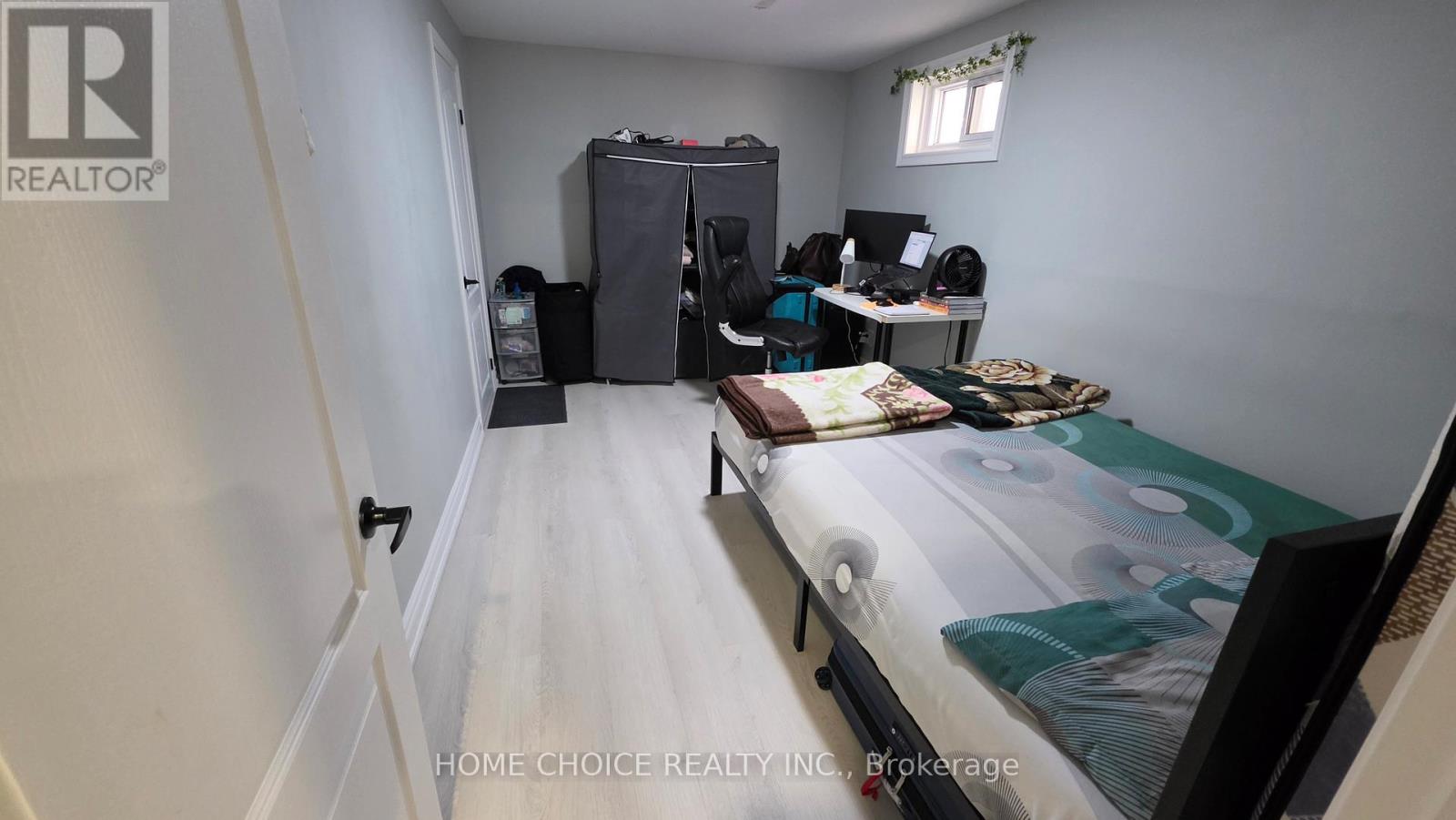 A bedroom with a bed, desk, and chair.