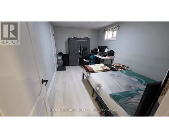 A bedroom with a bed, desk, and chair.
