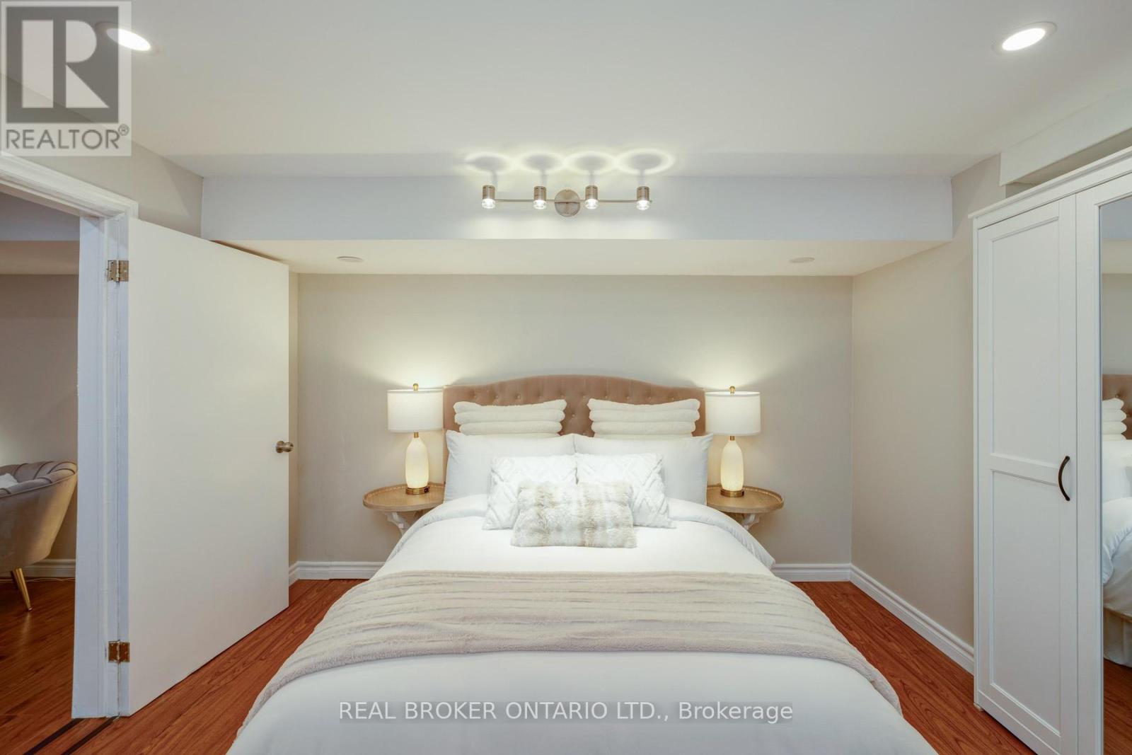 A bedroom with a large bed and two lamps on side tables.