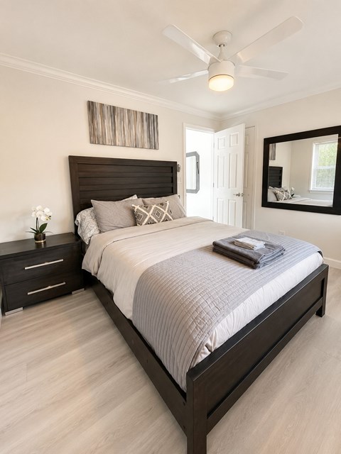 A bedroom with a large bed and a ceiling fan.