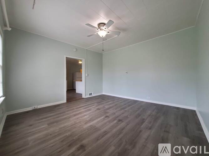 A room with wooden flooring and a ceiling fan.