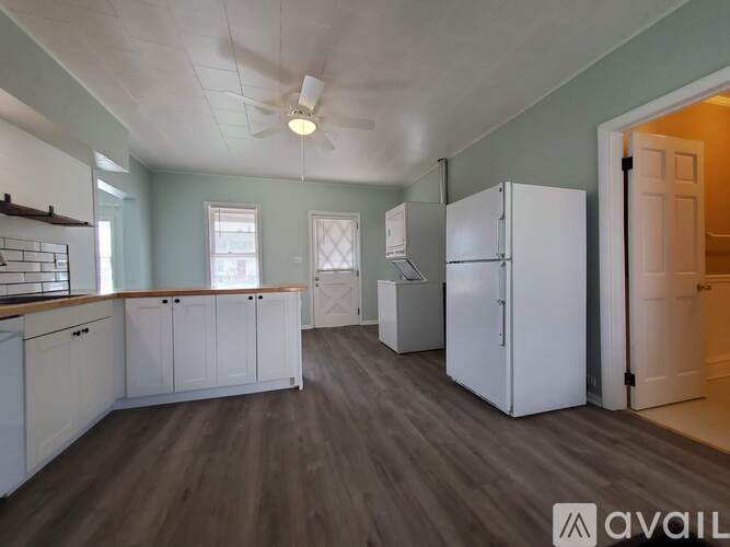 A kitchen with white cabinets and a refrigerator.