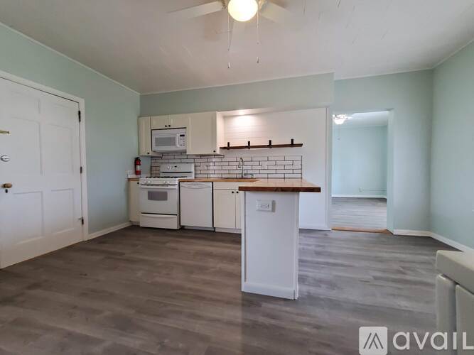 A kitchen with a white cabinet and a wooden countertop.