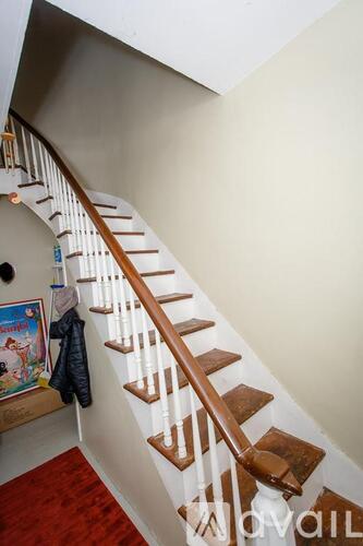 A staircase with a red carpet at the bottom.