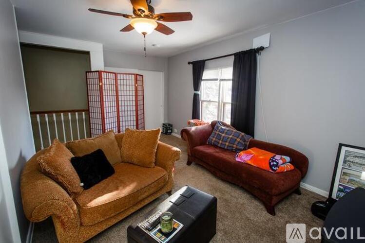 A living room with a brown couch and a red couch.