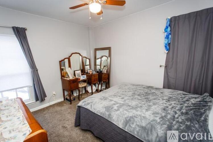A bedroom with a bed, dresser, and mirror.