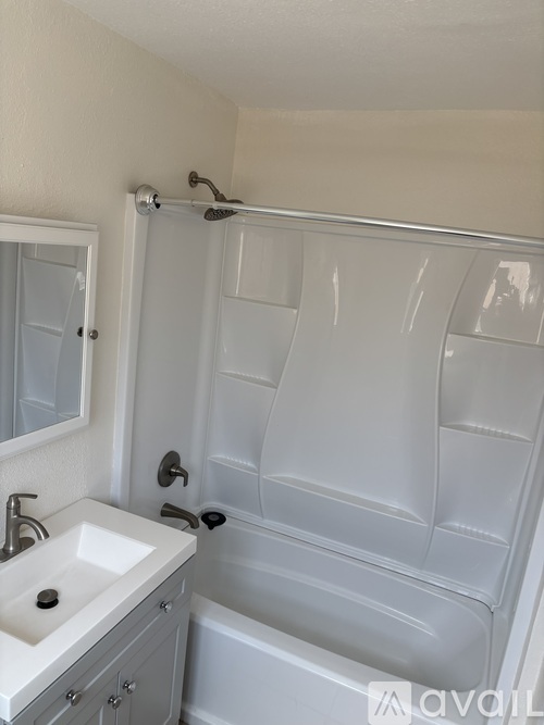 A white bathroom with a white tub and sink.