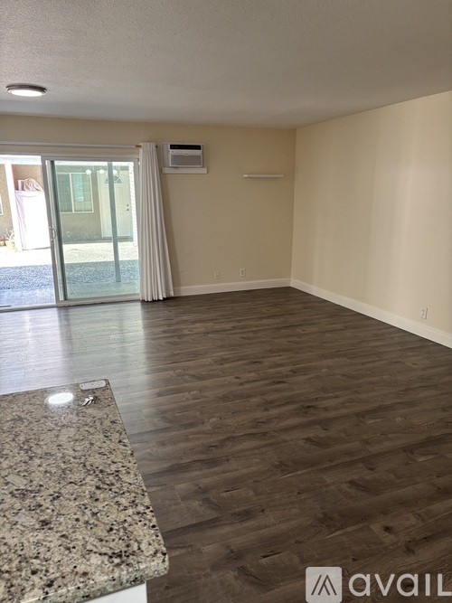 A room with wooden flooring and a granite countertop.