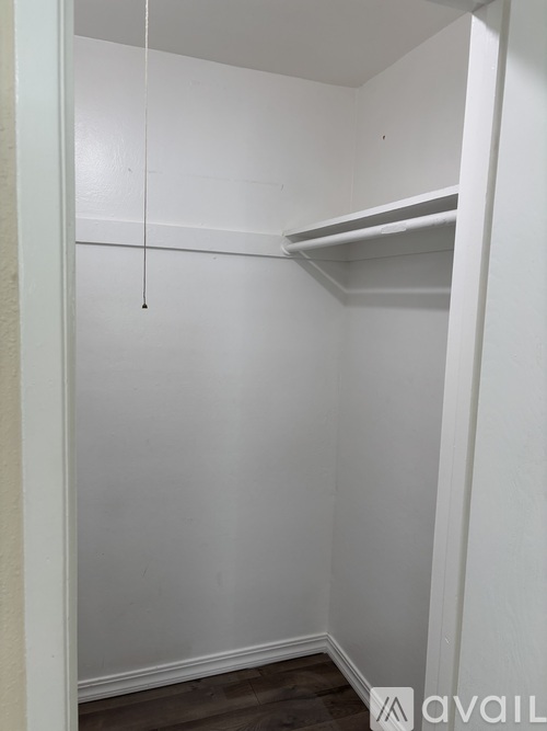 A small white closet with a shelf and a hanging rod.