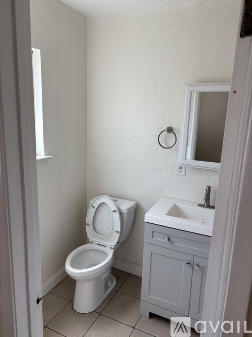 A white toilet and sink in a small bathroom.