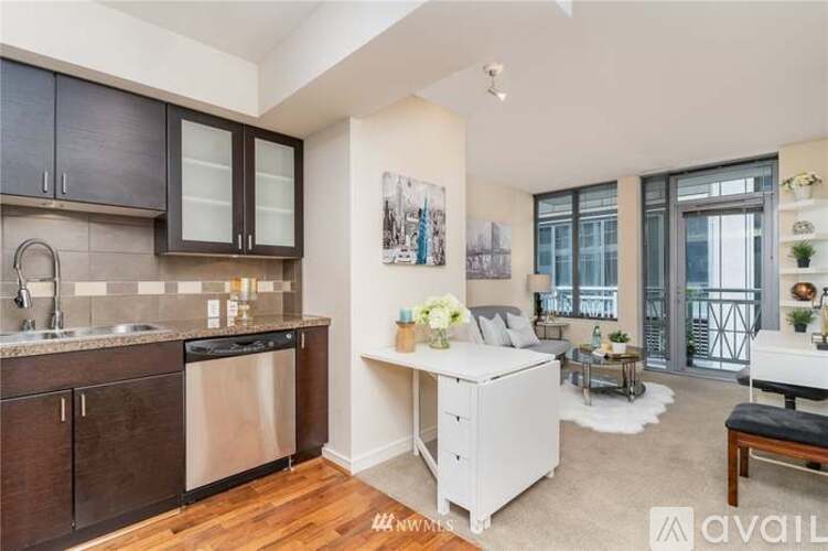 A kitchen with dark brown cabinets and a white dishwasher.
