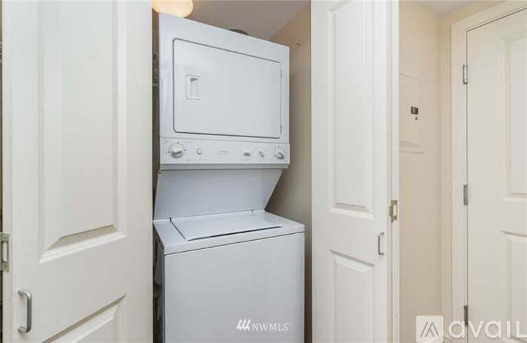 A white dishwasher and oven are stacked on top of each other in a small space.