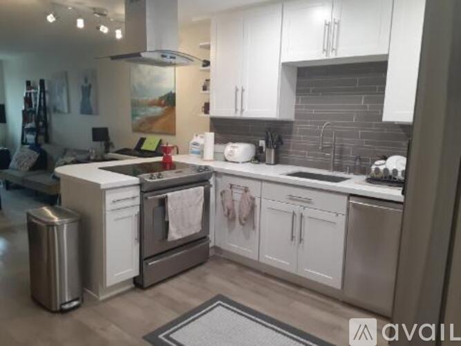 A modern kitchen with white cabinets and stainless steel appliances.