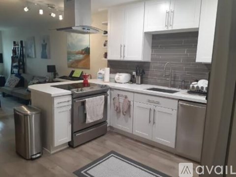 A modern kitchen with white cabinets and stainless steel appliances.
