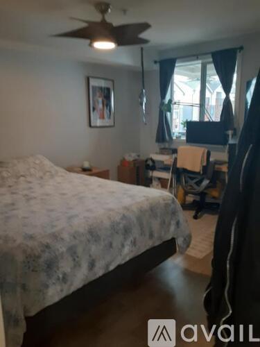 A bedroom with a bed, desk, and chair.