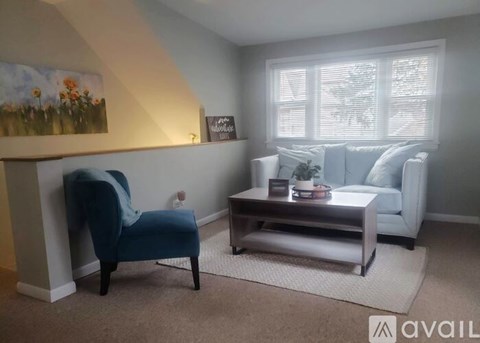 A living room with a blue chair and a grey sofa.