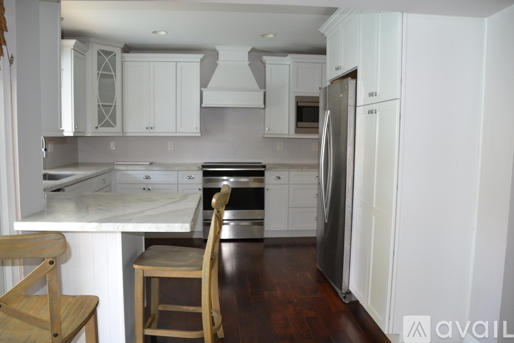 A kitchen with white cabinets and a wooden table.