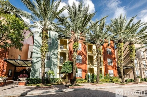 A row of palm trees in front of a building.