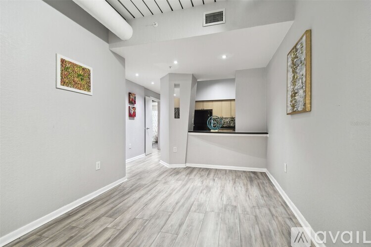 A spacious room with wood flooring and two pieces of artwork on the wall.