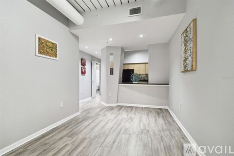 A spacious room with wood flooring and two pieces of artwork on the wall.