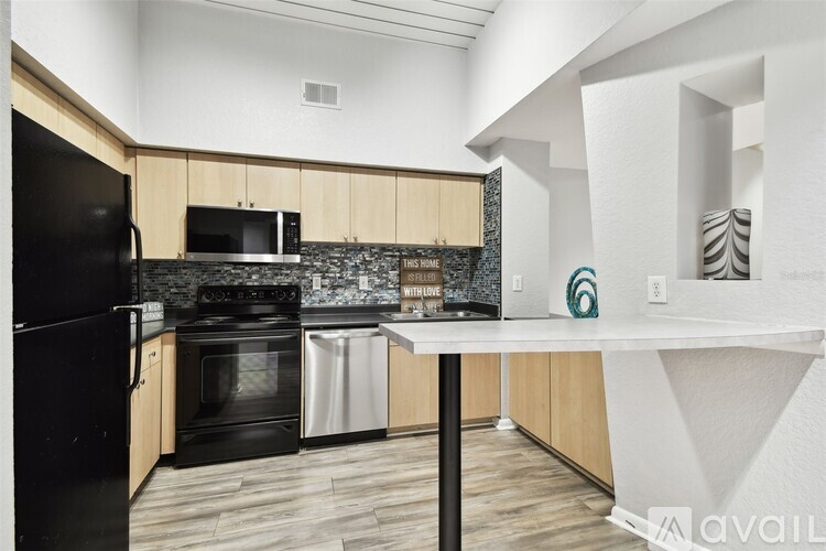 A kitchen with a black refrigerator and a stainless steel dishwasher.